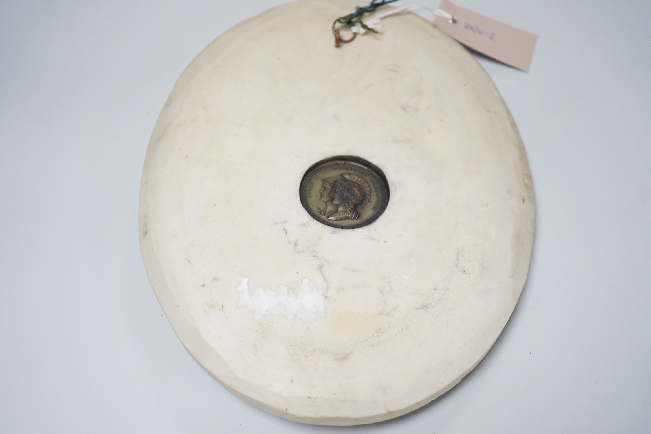 A reproduction reconstituted marble oval plaque with inset coin to reverse, 30cm